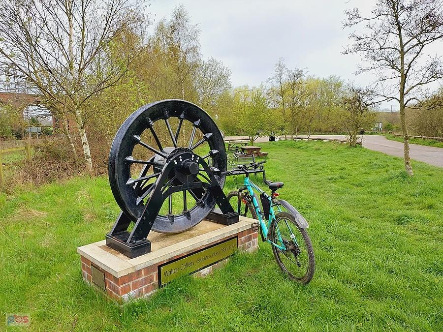 Duże czarne koło napędowe i rower przy ścieżce Trans Pennine Trail