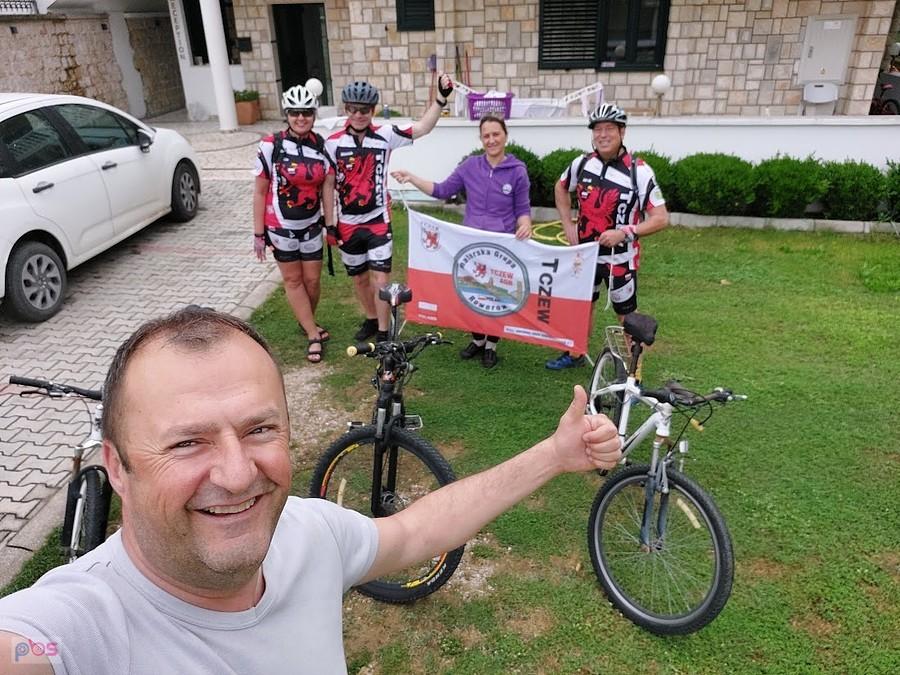Grupa rowerzystów na wycieczce z flagą