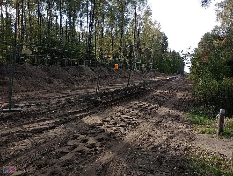 Droga rozjeżdżona przez koparkę na gąsienicach. Budowa gazociągu również w lesie