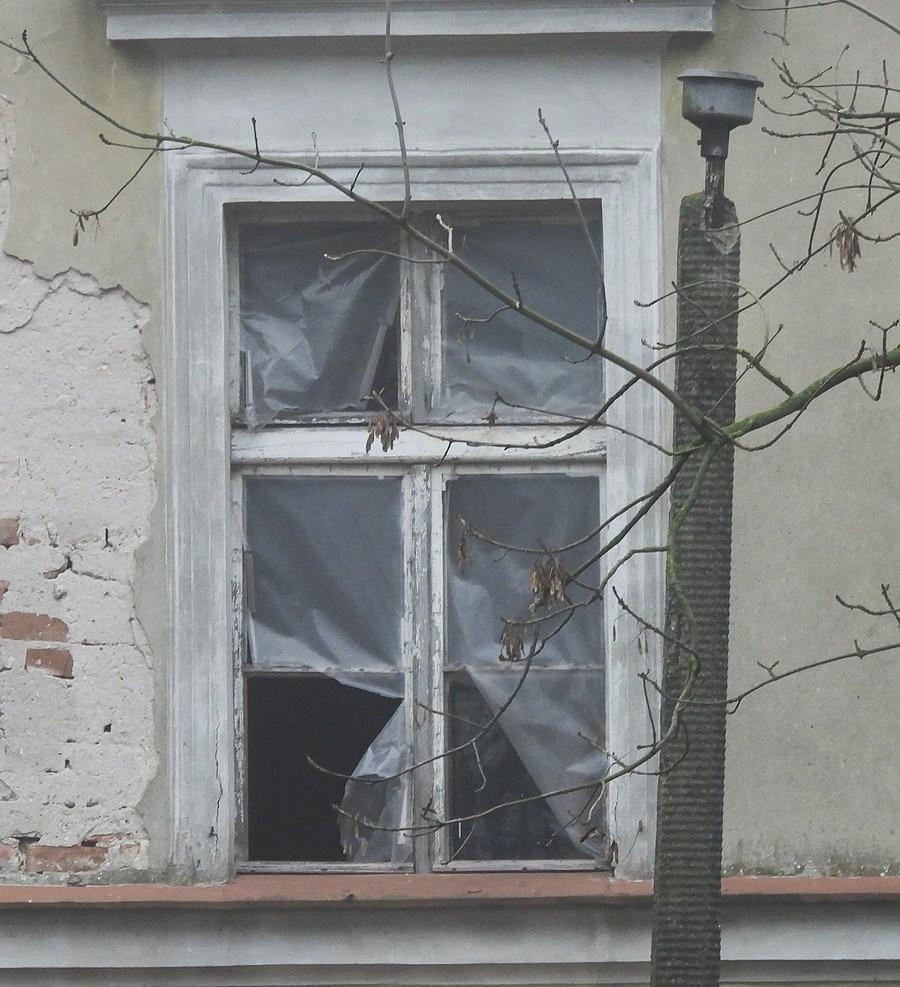 Zbliżenie na zdewastowane dworskie okno