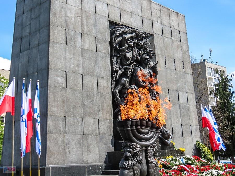 Znicz w kształcie menory przed pomnikiem Bohaterów Getta