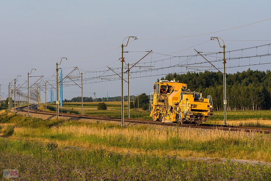 Zgarniarka tłucznia ZTU-300 Nr 12 na szlaku CMKi (linia D29-4): Psary - Góra Włodowska mija pogranicze wsi Przyłęk i Brzostek.