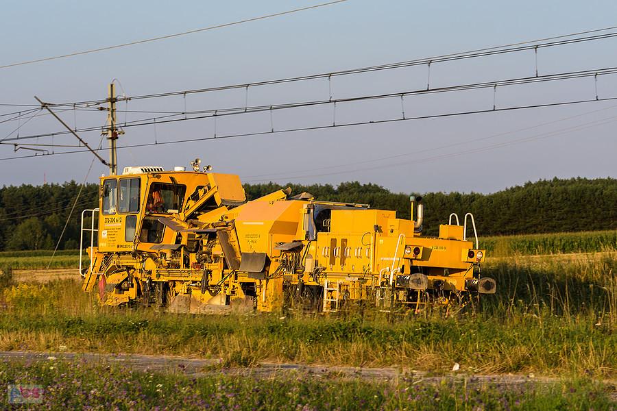 Zgarniarka tłucznia ZTU-300 Nr 12 na szlaku CMKi (linia D29-4): Psary - Góra Włodowska mija pogranicze wsi Przyłęk i Brzostek.