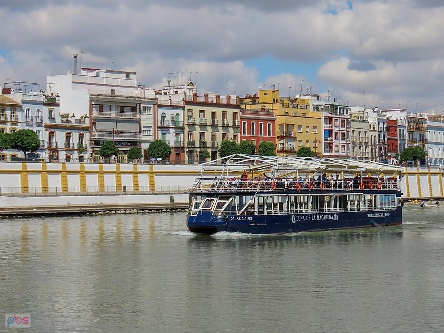 Statek wycieczkowy na tle kolorowej zabudowy zabytkowej dzielnicy Triana