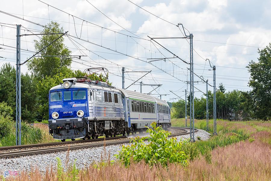 Szlak: podg. Kucelinka - Częstochowa Stradom, linia D29-61. EP07-1018 z poc. TLK 37100 "Miechowita" relacji: Kraków Główny - Poznań Główny mija dzielnicę Błeszno.