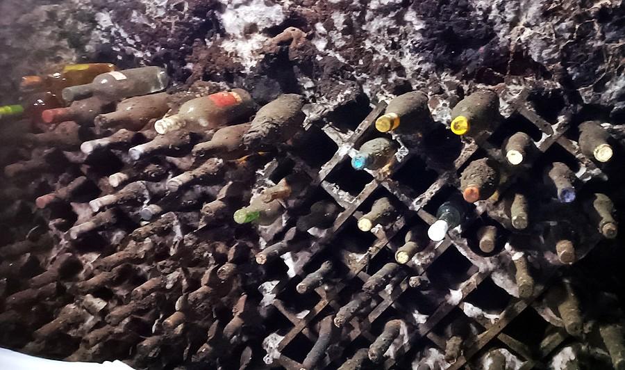 Butelki z winem leżakują w sprzyjających warunkach w chłodnych i pokrytych plęśnią piwniczkach
