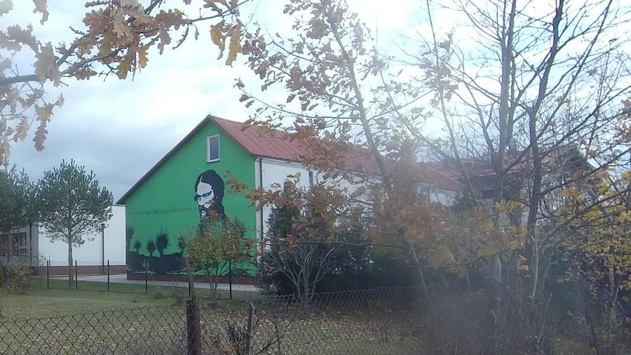Do kraju tego gdzie gniazda bocianie..., parafraza i mural poety na szkole w Strachówce