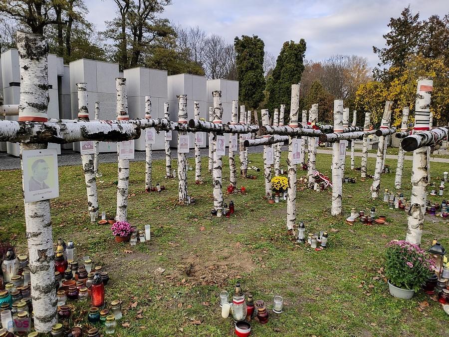 Na krzyżach umieszczone są zdjęcia osób, których szczątki odnaleziono na "łączce"