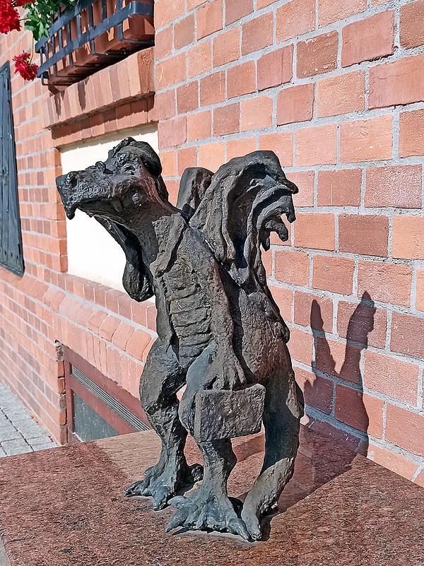 Smok-urzędnik stoi  przy ratuszu